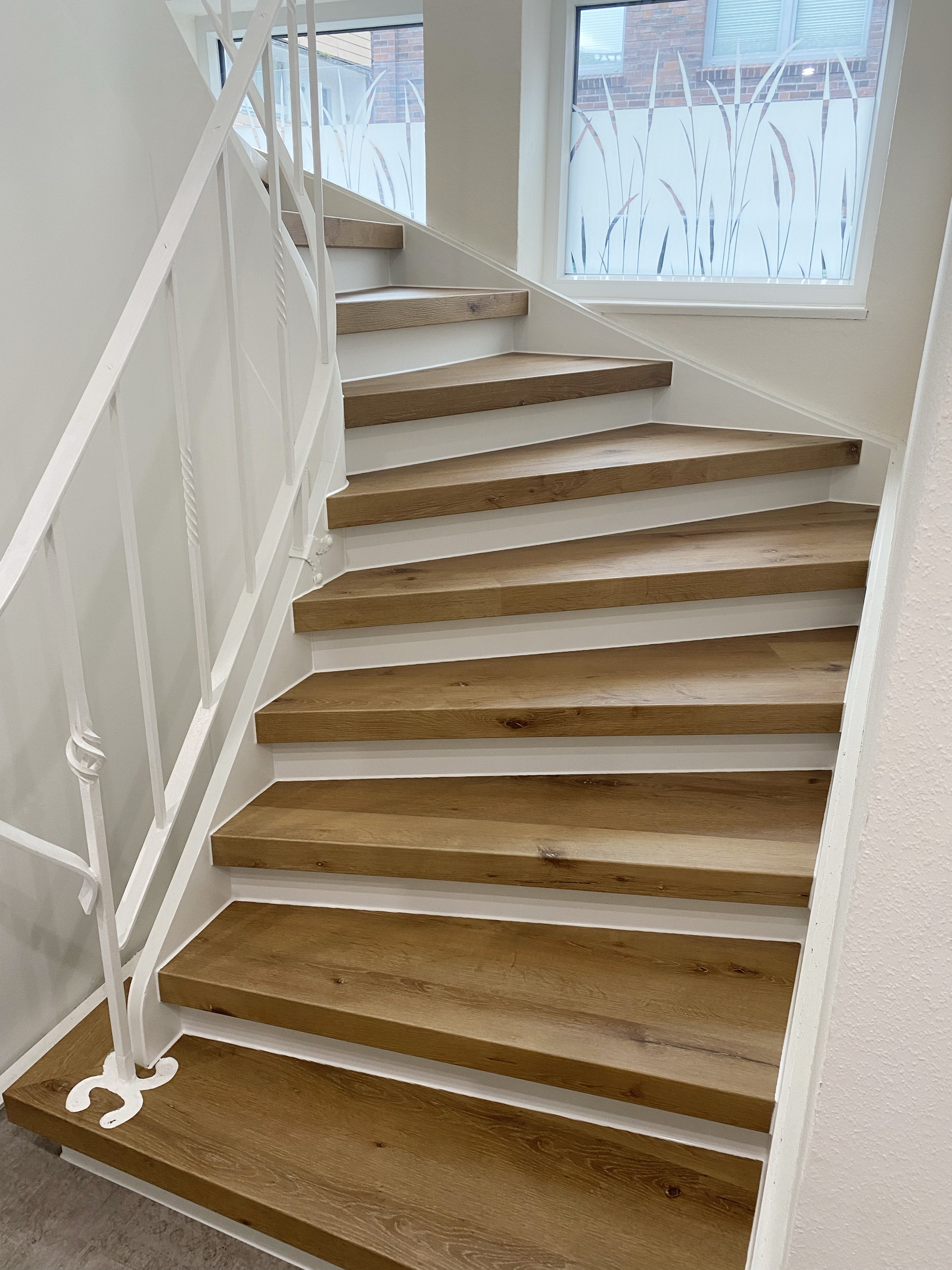 Fertig renovierte Treppe mit Tilo-Treppensystem – Eichenstufen und weiße Setzstufen