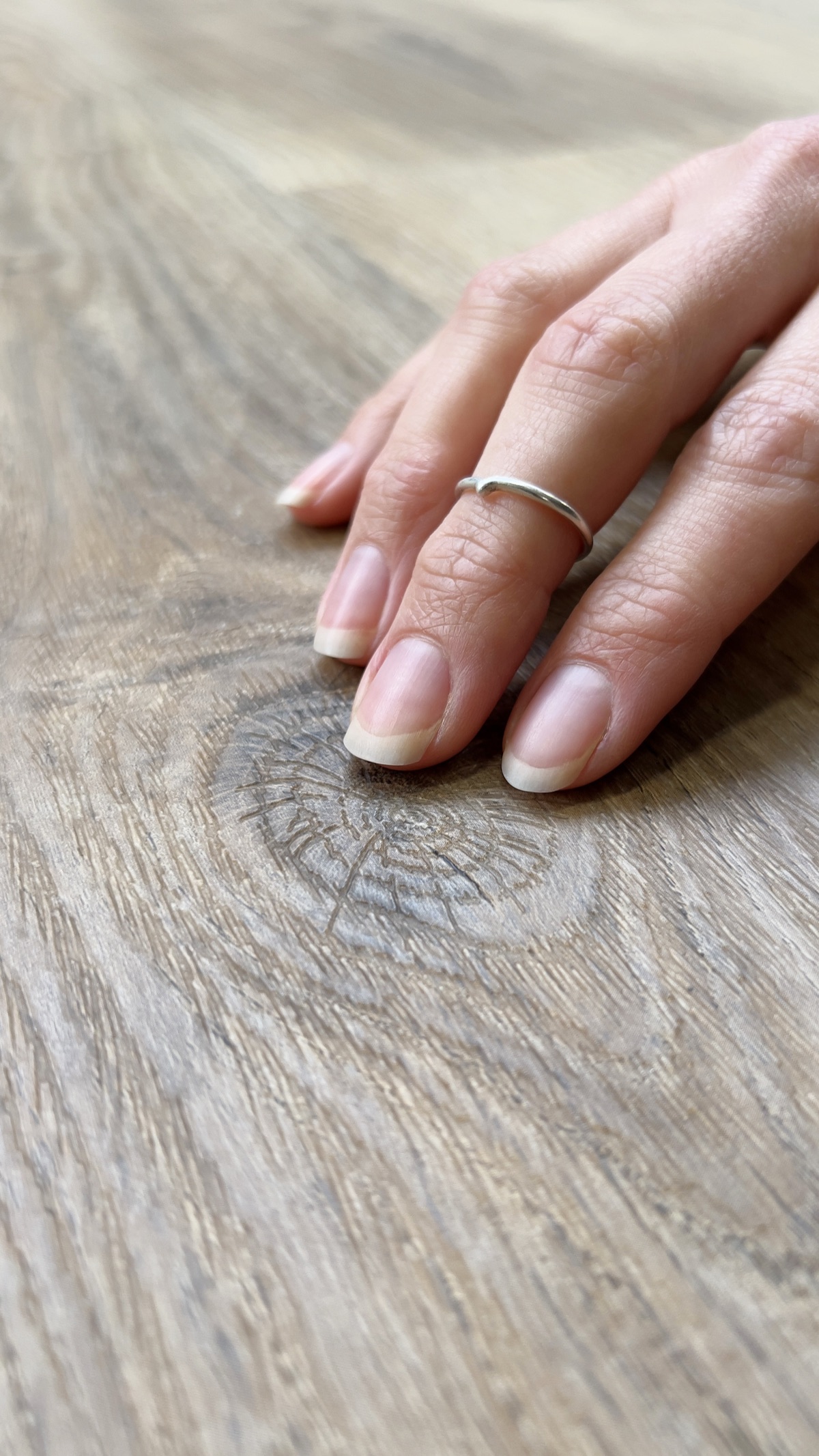 Hand streicht über die Holzstruktur eines Klick-Vinylbodens